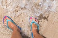 Woman legs stands in sea water on a tropic beach Royalty Free Stock Photo