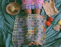 Woman legs with warm in wintertime, crocheted colorful blanket by link many pieces artwork