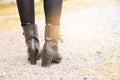 A woman legs wearing black boots high heel.