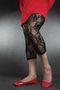 Woman legs wearing black lace leggins and red dress
