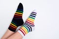 Woman legs wearing funny bright different striped colorful socks on white background with copy space. Flat lay Royalty Free Stock Photo