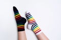 Woman legs wearing funny bright different striped colorful socks on white background with copy space. Flat lay Royalty Free Stock Photo