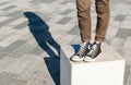 Woman legs wearing skinny brown trousers and black sneakers Royalty Free Stock Photo