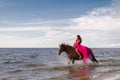 Woman leisurely rides her horse along the shoreline of a tranquil lake