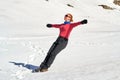 Woman letting herself fall on her back in snow with her arms spread out - trust exercise. Location: Bucegi mountains, Romania Royalty Free Stock Photo