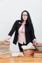 a female librarian teacher stands near a stack of books Royalty Free Stock Photo