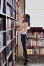 Woman, library and bookshelf for reading, knowledge or learning literature at the book store. Female person or academic