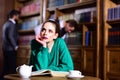Woman in library read book at teapot drinking coffee from cup. literature cafe with cute girl and men. student life in Royalty Free Stock Photo