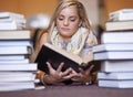 Woman, library and reading book on floor for literature, learning or knowledge at bookstore. Young female person Royalty Free Stock Photo