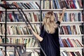 Woman in a library take a book from bookshelf