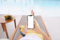 Woman lie down on pool bed touching phone white screen Royalty Free Stock Photo