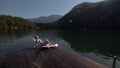 Woman lie on a sunbed in sunglasses and a boho silk shawl. Girl rest on a flood wood underwater pier. The pavement is