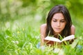 Woman lies on grass and reads book