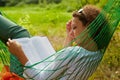 Woman lies in hammock and reads book