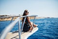 Young woman lies on a luxury yacht in the sea and looking to the horizon Royalty Free Stock Photo