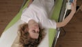 A woman lies on a massage electronic bed.