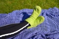 Lying on green grass in knitted socks in summer. Relax in garden in morning.