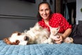 A woman lies on a sofa with a cat and a dog. Love for pets concept Royalty Free Stock Photo