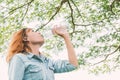 Woman life : young beautiful woman drinking water at green park