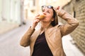 Woman lifting sunglasses and looking up while eating ice cream. Royalty Free Stock Photo