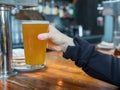 Woman lifting up pint glass of IPA beer in a bar Royalty Free Stock Photo