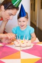 Woman lighting candles on birthday cake and child smiling Royalty Free Stock Photo