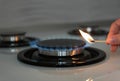 Woman lighting gas stove with match