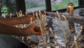 Woman lighting prayer candle aka offering, sacrificial or memorial candles lit in a church Royalty Free Stock Photo