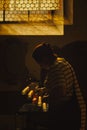 Woman lights candle in Salzburg Franciscan Church