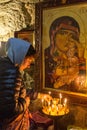 Woman lights candles in Georgian Orthodox church