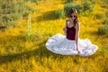 Woman like a fairy on the magic field near the river. Young woman with dandelion. Fantasy style