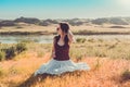 Woman like a fairy on the magic field near the river. Young woman with dandelion. Fantasy style