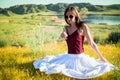 Woman like a fairy on the magic field near the river. Young woman with dandelion. Fantasy style