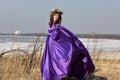 Woman lilac dress with a wreath of flowers on her head on nature