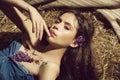 Woman with lilac flowers lying on hay