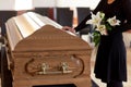 Woman with lily flowers and coffin at funeral Royalty Free Stock Photo