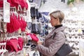 A woman in a lingerie store finds it difficult to make a choice. Fashion and beauty. Side view. Close-up