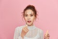 Woman with lip gloss. Photo of woman with perfect makeup on pinkbackground. Beauty concept