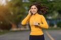 Woman listening music on earphones while running in park Royalty Free Stock Photo