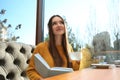 Woman listening to audiobook at table in cafe Royalty Free Stock Photo