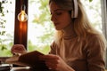 Woman listening to audiobook at table in cafe, closeup Royalty Free Stock Photo