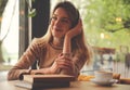 Woman listening to audiobook at table in cafe Royalty Free Stock Photo