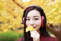 Young woman stand under tree Sea and listening to music with headphones Royalty Free Stock Photo