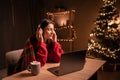 Woman listening to music with headphones while sitting at home office late at night on christmas eve Royalty Free Stock Photo