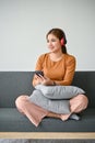 A woman listening to music through her headphones while relaxing in her living room Royalty Free Stock Photo