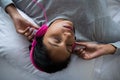 Woman listening to music while sleeping on bed Royalty Free Stock Photo