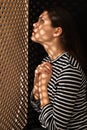 Woman listening to priest during confession near wooden partition in booth Royalty Free Stock Photo