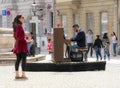 Woman listening to a street musician playing piano