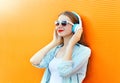 Woman listens and enjoys music in headphones over colorful Royalty Free Stock Photo