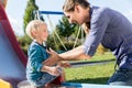 Woman and little boy chuting down slide at playground Royalty Free Stock Photo